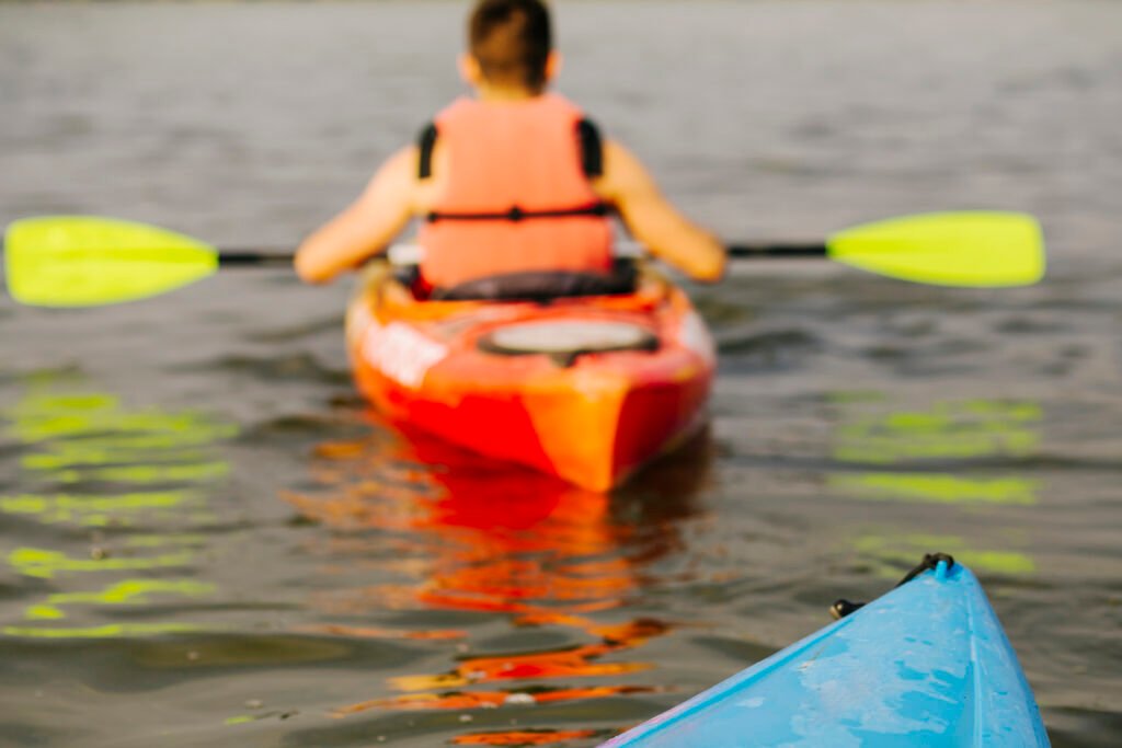 slightly blurred image of kayakers in safety vests from behind